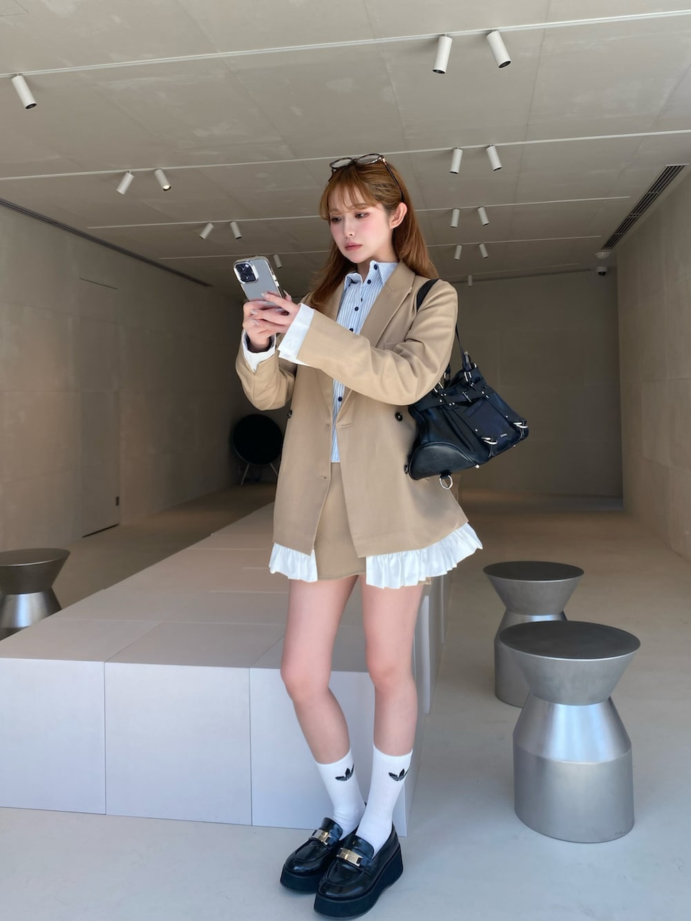 ベージュ系のテーラードジャケット、ベージュ系のスカート、ブラウン系のその他シューズを着用したレディースの春コーディネートの2枚目の写真