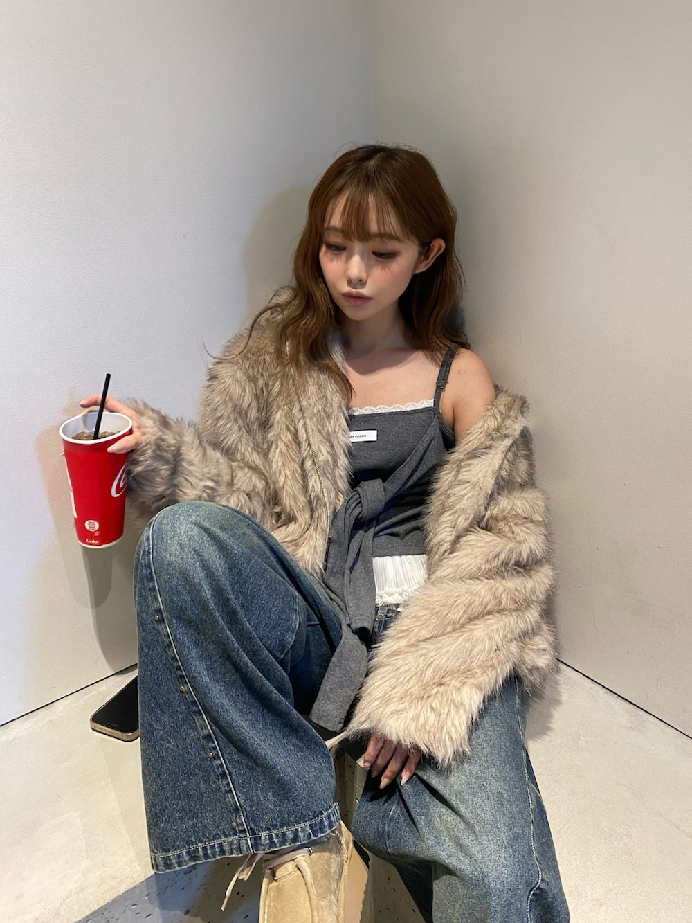 ホワイト系のブルゾン、ブラック系のショルダーバッグ、ブルー系のデニムパンツを着用したレディースの秋コーディネートの4枚目の写真