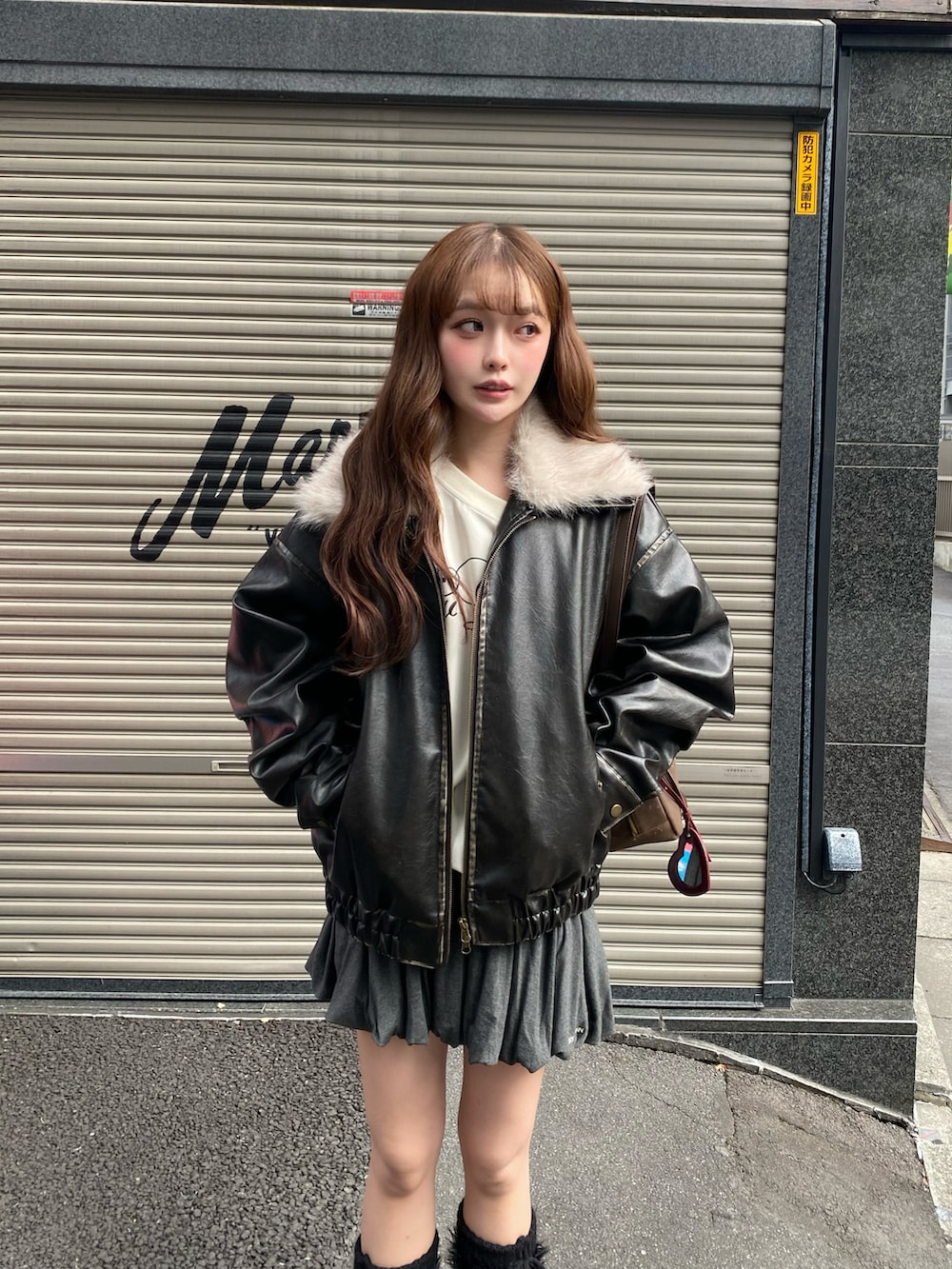 ブラック系のブルゾン、ベージュ系のスウェット、ブラウン系のトートバッグを着用したレディースの秋コーディネートの4枚目の写真