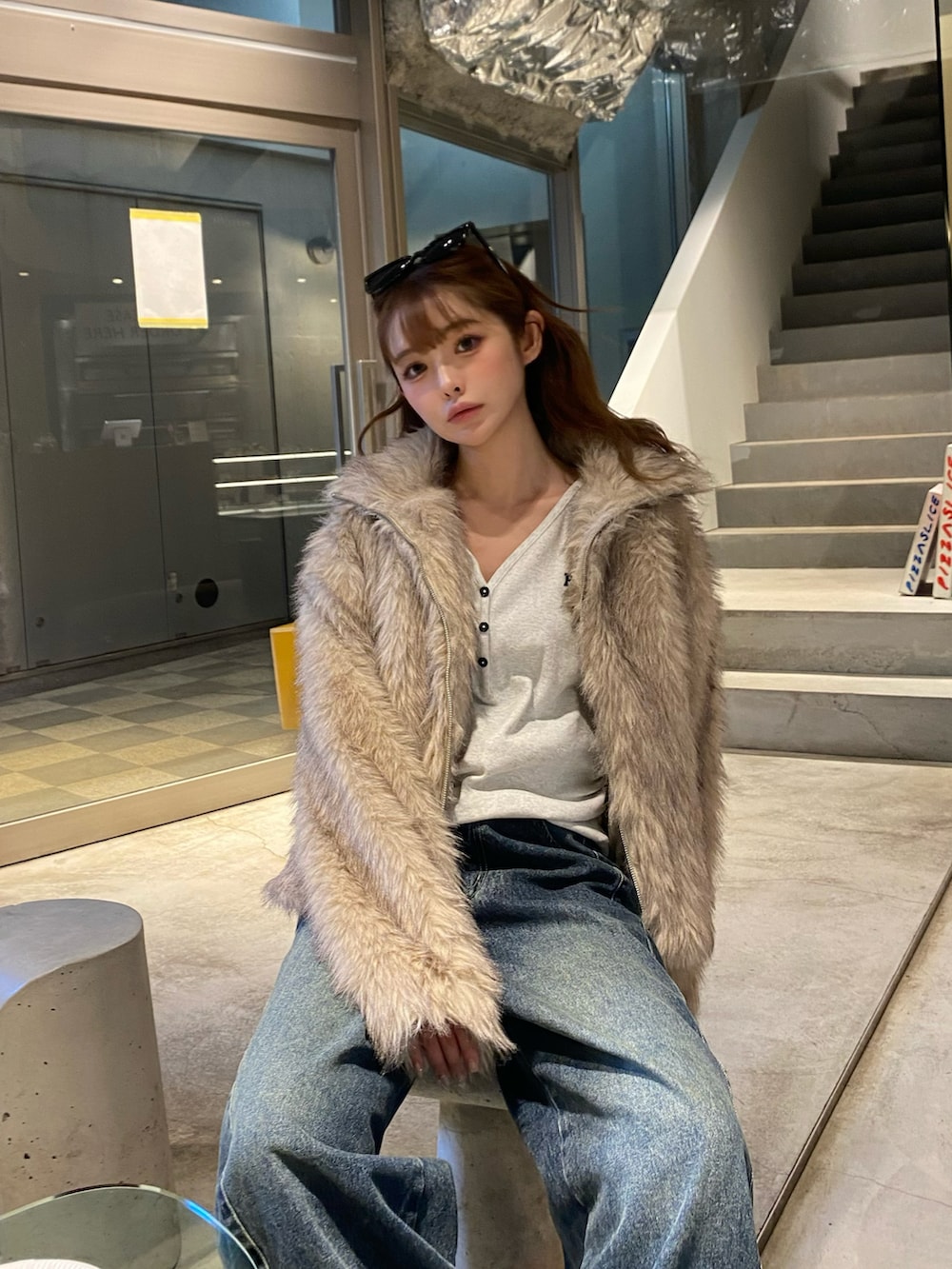 ホワイト系のブルゾン、ブラック系のショルダーバッグ、ブルー系のデニムパンツを着用したレディースの秋コーディネートの5枚目の写真