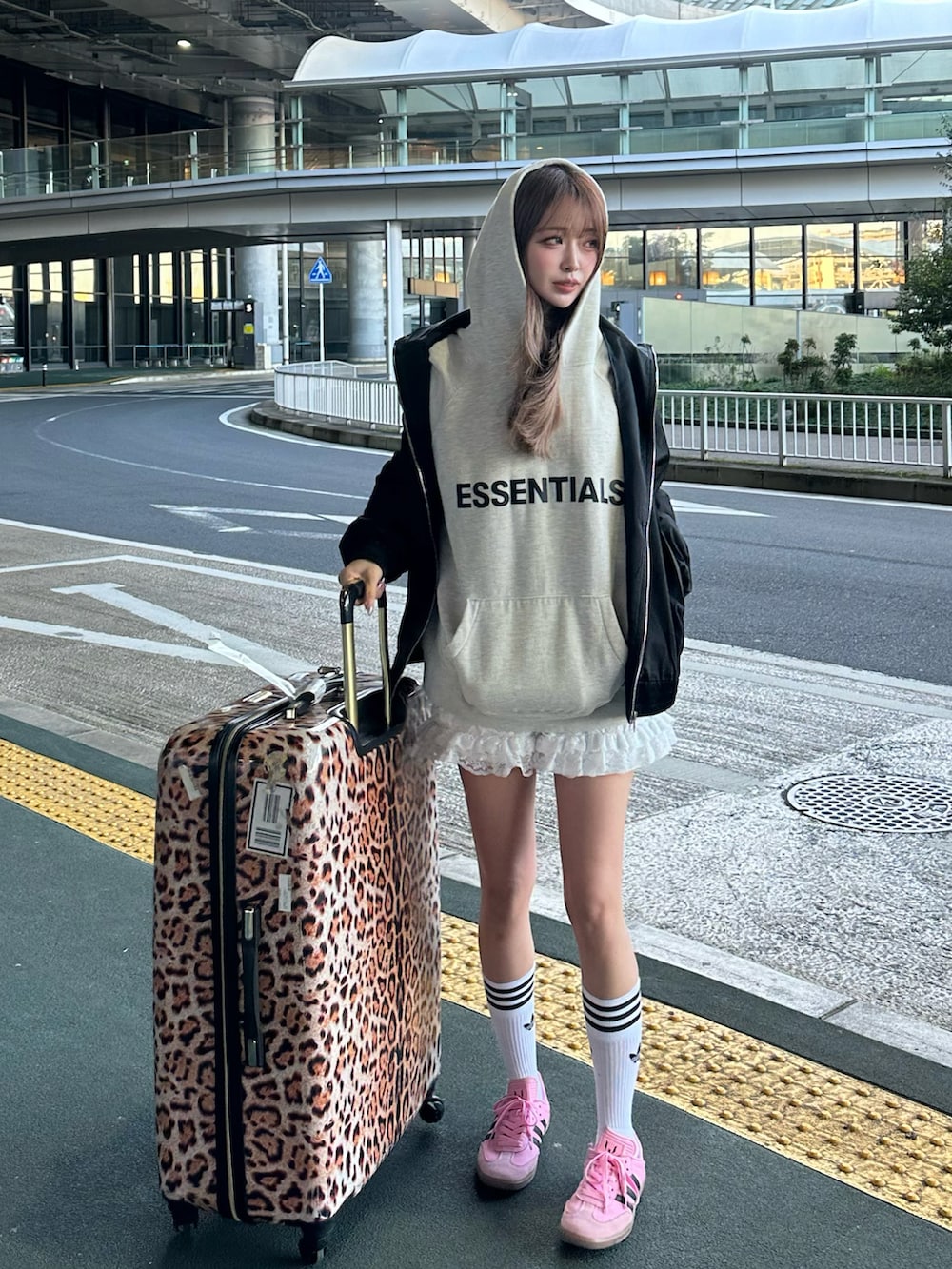 ホワイト系のパーカー、ブラック系のブルゾン、ホワイト系のパンツを着用したレディースの春コーディネートの2枚目の写真