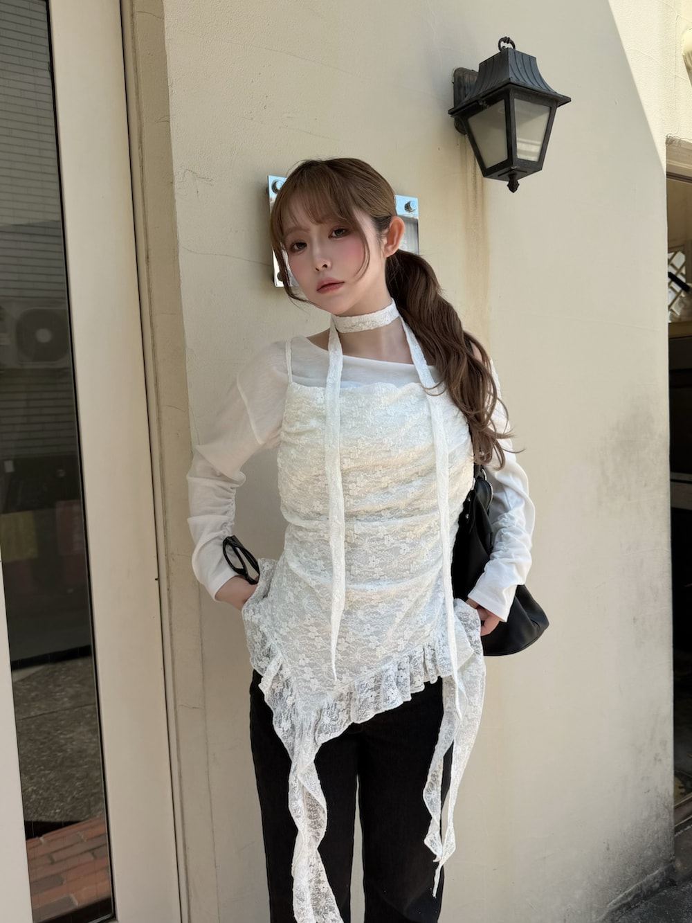 ホワイト系のキャミソール、ブラック系のデニムパンツ、ブラック系のスニーカーを着用したレディースの春コーディネートの2枚目の写真