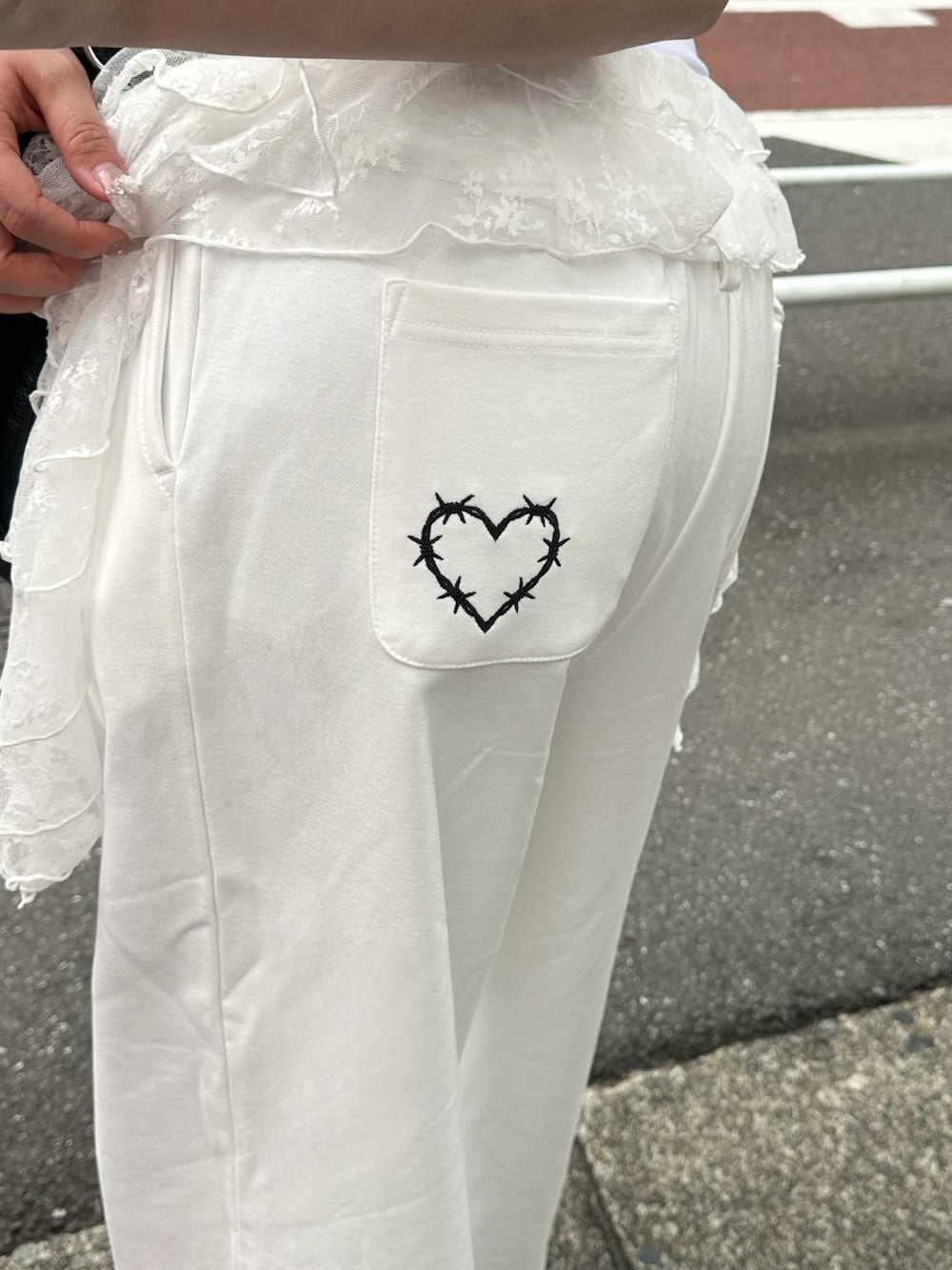 ブラック系のショルダーバッグ、ホワイト系のスウェットパンツ、ホワイト系のTシャツ/カットソーを着用したレディースの春コーディネートの3枚目の写真