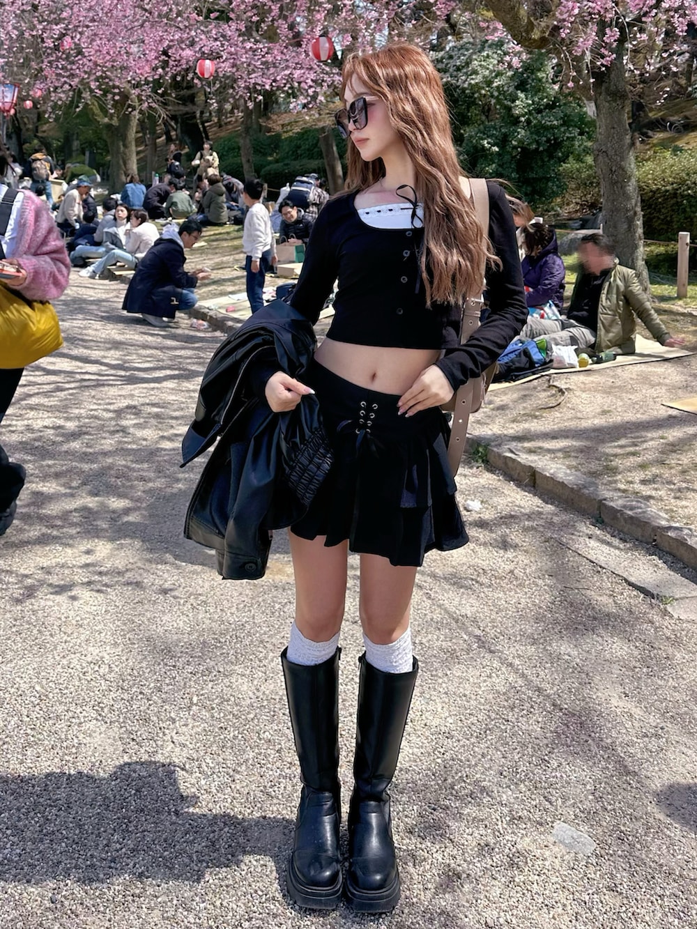 ブラック系のスカート、ブラック系のTシャツ/カットソー、ベージュ系のショルダーバッグを着用したレディースの春コーディネートの2枚目の写真