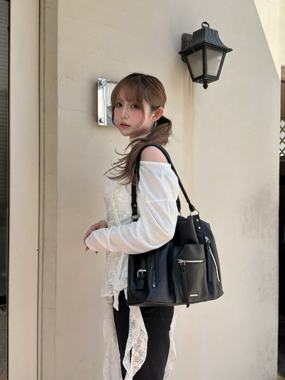 ホワイト系のキャミソール、ブラック系のデニムパンツ、ブラック系のスニーカーを着用したレディースの春コーディネートの3枚目の写真