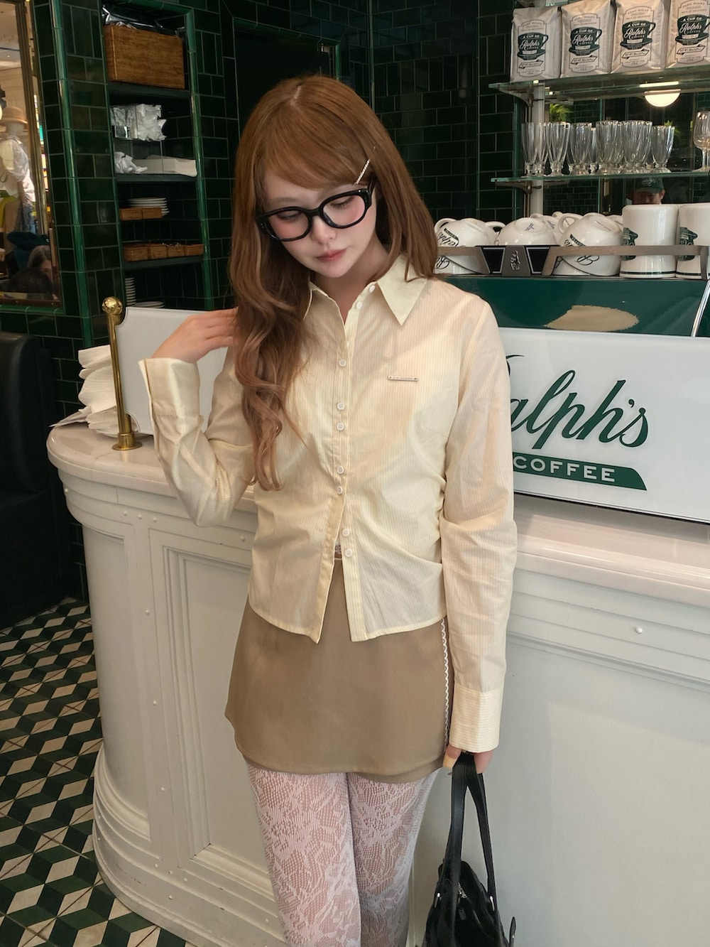 ベージュ系のスカート、ブラック系のショルダーバッグ、イエロー系のシャツ/ブラウスを着用したレディースの冬コーディネートの3枚目の写真