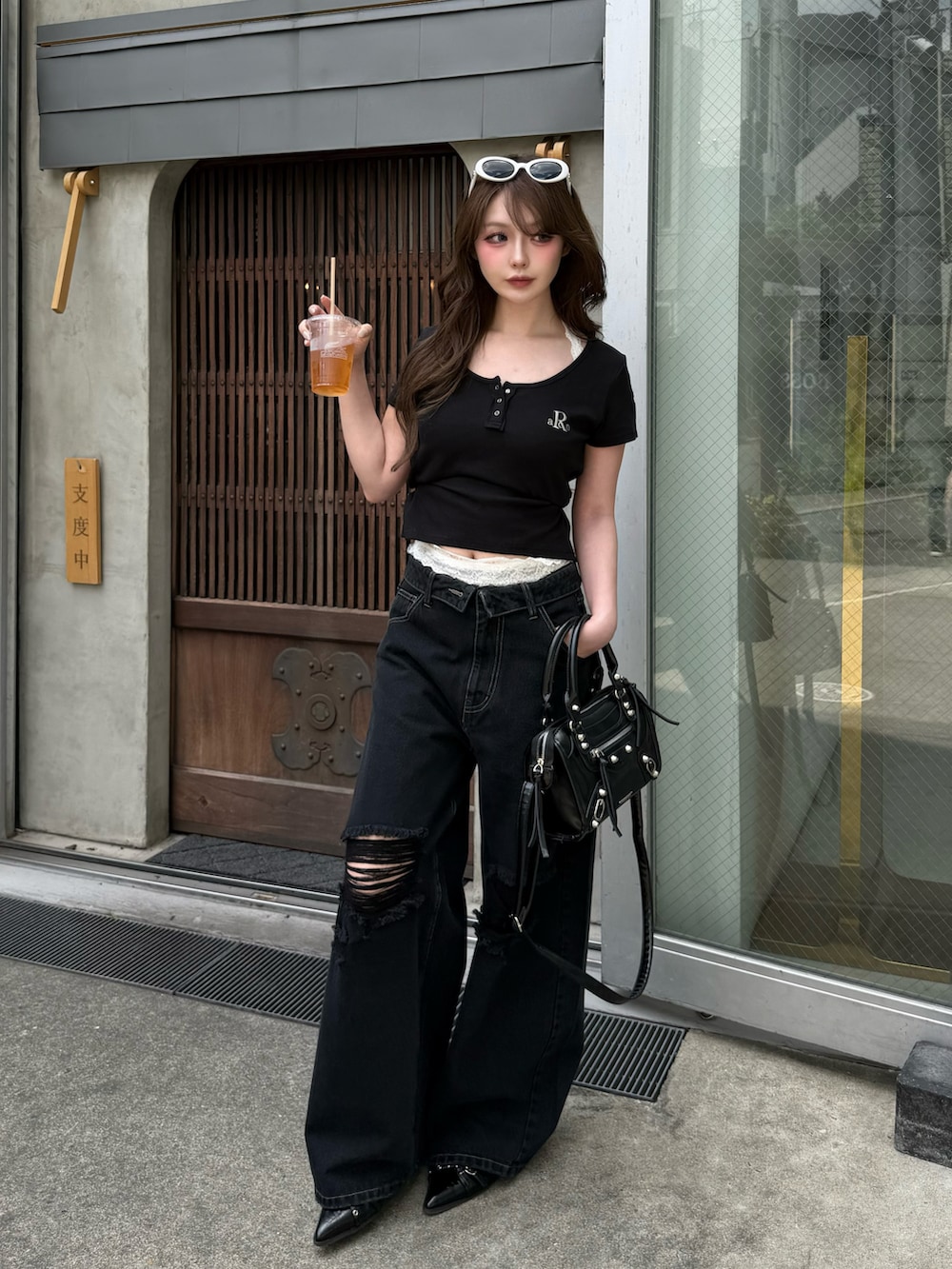 ブラック系のTシャツ/カットソー、ブラック系のデニムパンツ、ブラック系のその他シューズを着用したレディースの春コーディネートの2枚目の写真