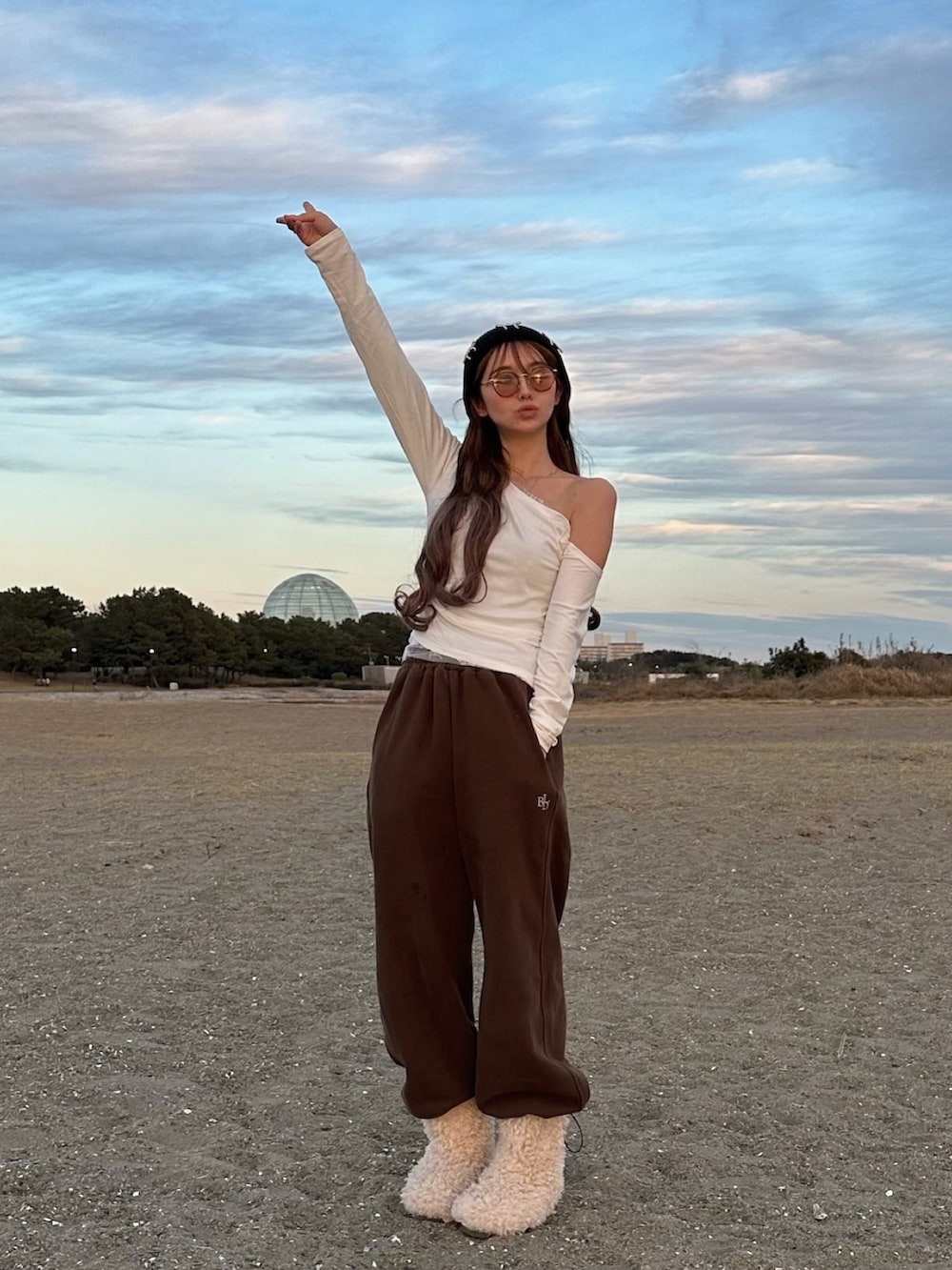 ブラウン系のスウェットパンツ、ベージュ系のブーツ、ホワイト系のMA-1を着用したレディースの冬コーディネートの2枚目の写真