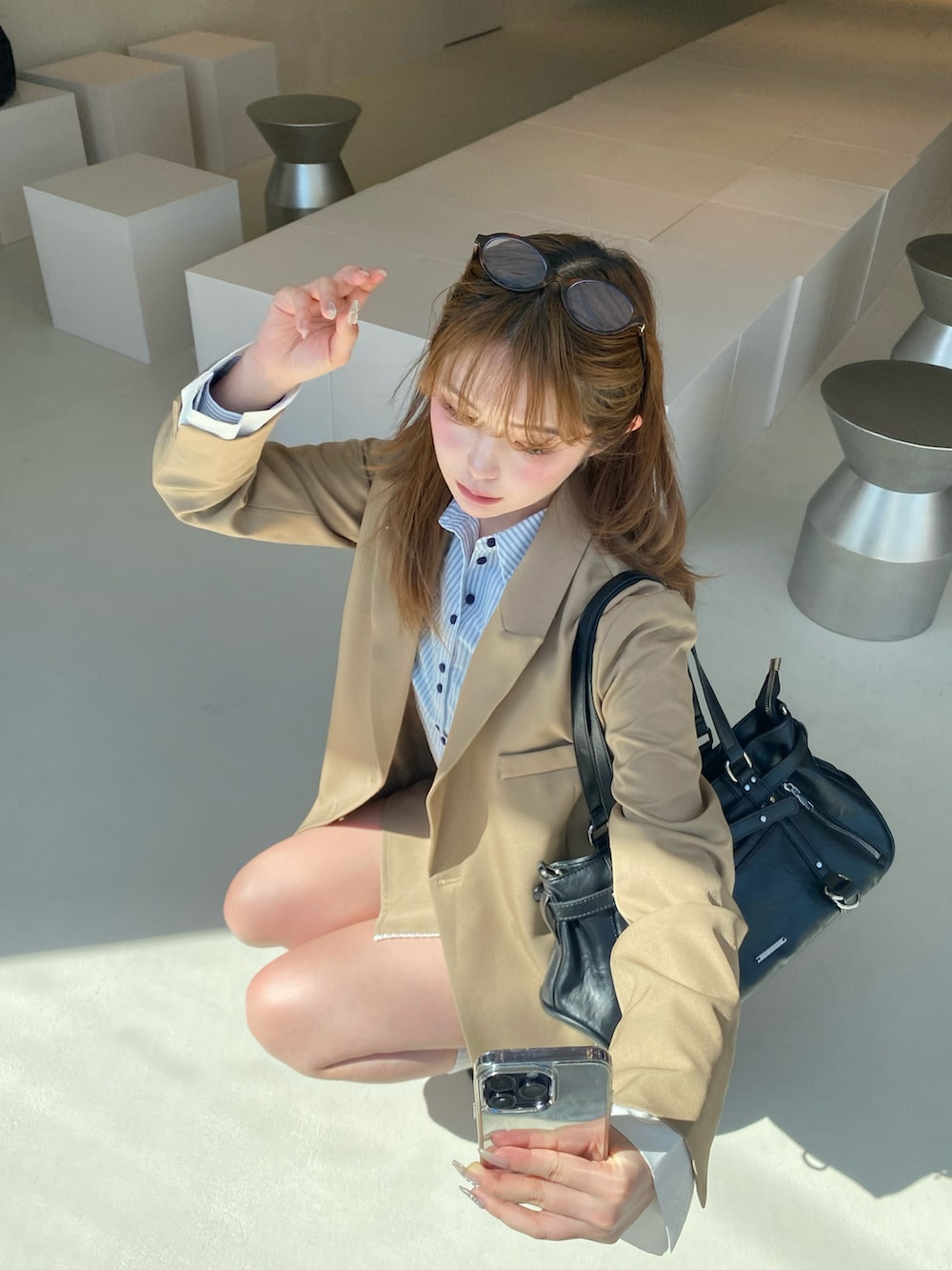 ベージュ系のテーラードジャケット、ベージュ系のスカート、ブラウン系のその他シューズを着用したレディースの春コーディネートの3枚目の写真