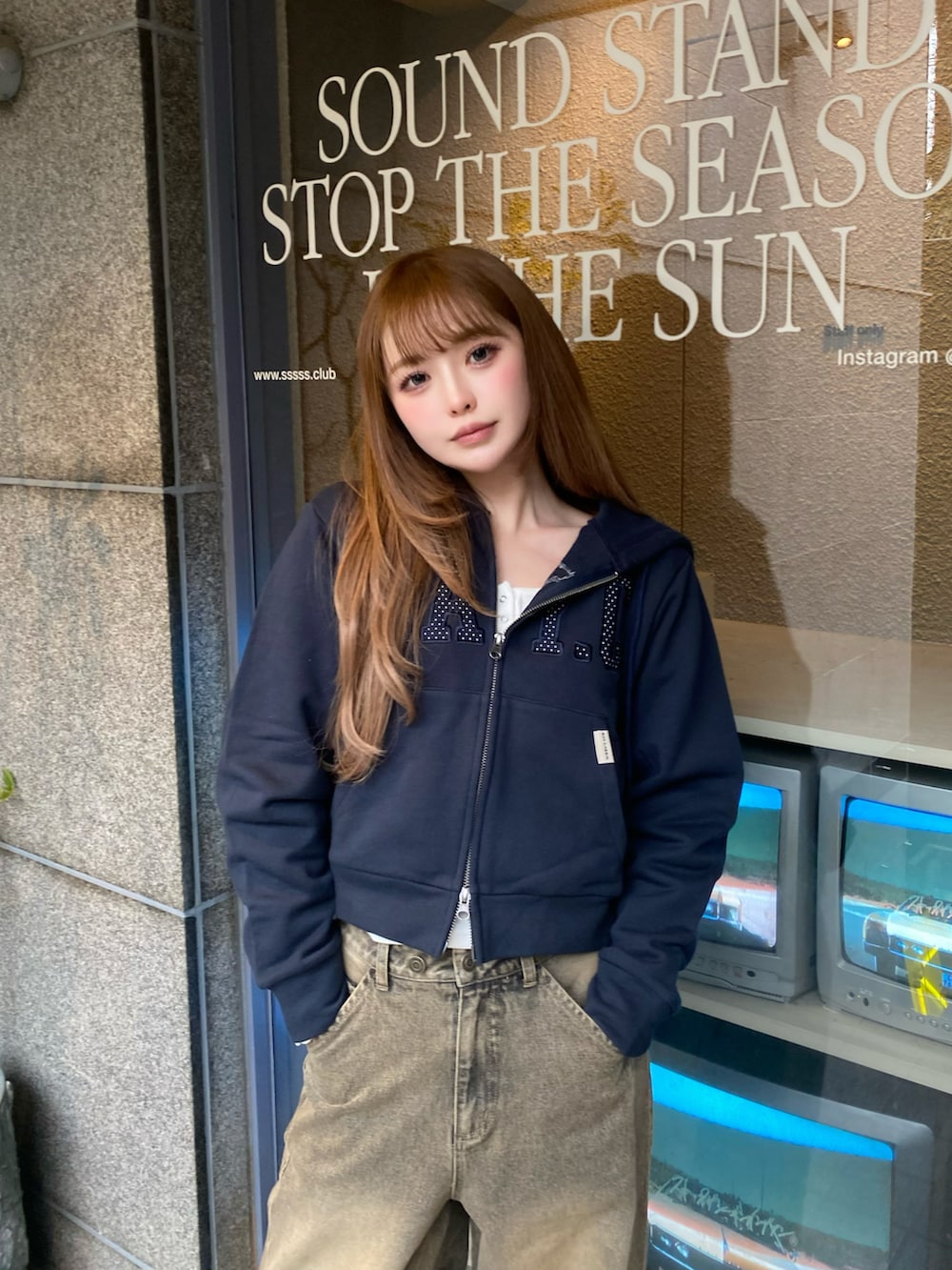 ブルー系のパーカー、ベージュ系のデニムパンツ、シルバー系のスニーカーを着用したレディースの春コーディネートの3枚目の写真