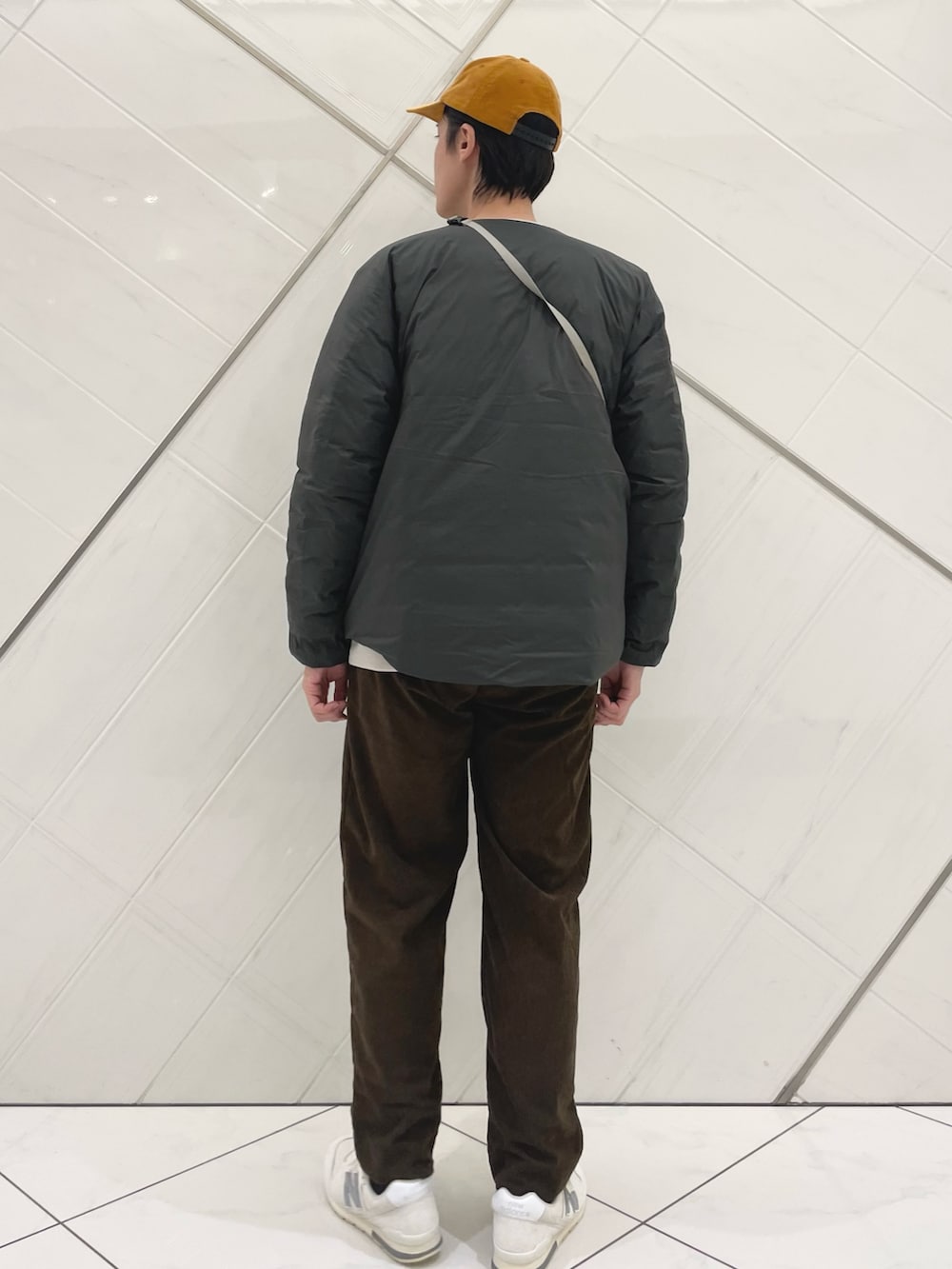 ブラウン系のダウンジャケット/コート、ベージュ系のTシャツ/カットソー、ブラウン系のその他パンツを着用したメンズの秋コーディネートの3枚目の写真