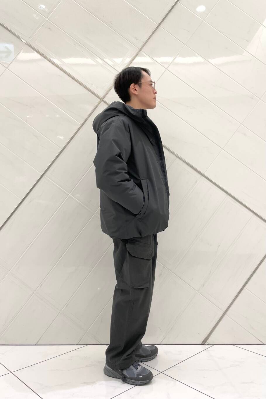 グレー系のその他パンツ、グレー系のスニーカー、グレー系のダウンジャケット/コートを着用したメンズの冬コーディネートの2枚目の写真