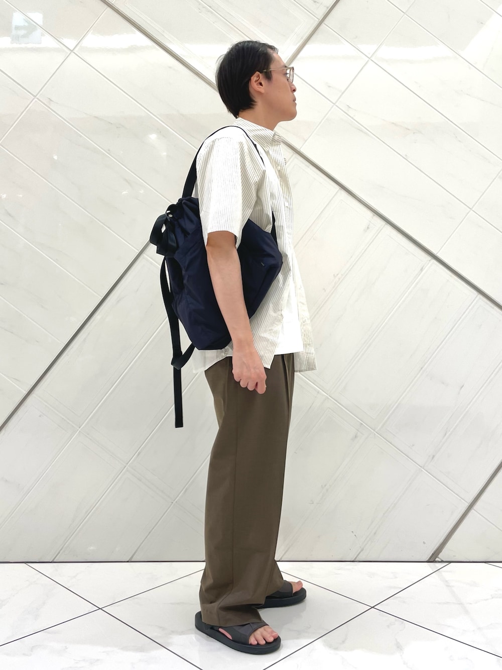 グレー系のサンダル、ホワイト系のTシャツ/カットソー、ブラウン系のその他パンツを着用したメンズの夏コーディネートの4枚目の写真