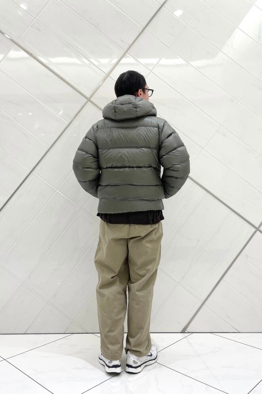 ホワイト系のスニーカー、ベージュ系のその他パンツ、グリーン系のダウンジャケット/コートを着用したメンズの冬コーディネートの4枚目の写真