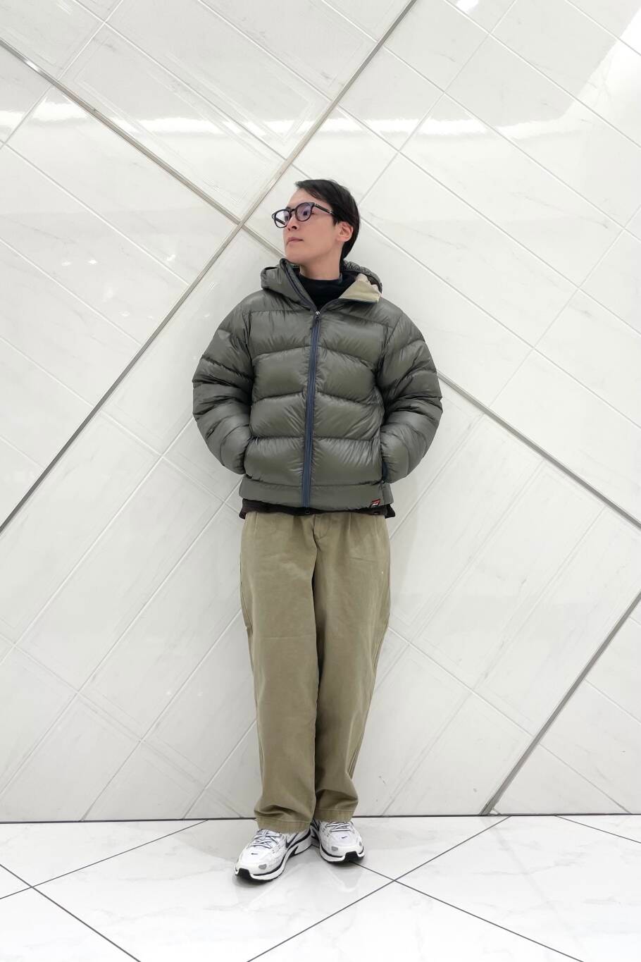 ホワイト系のスニーカー、ベージュ系のその他パンツ、グリーン系のダウンジャケット/コートを着用したメンズの冬コーディネートの3枚目の写真