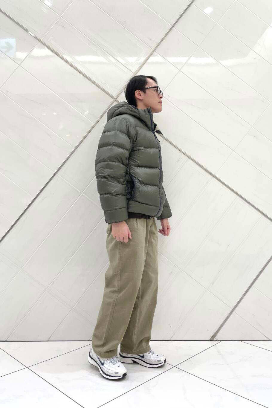 ホワイト系のスニーカー、ベージュ系のその他パンツ、グリーン系のダウンジャケット/コートを着用したメンズの冬コーディネートの5枚目の写真