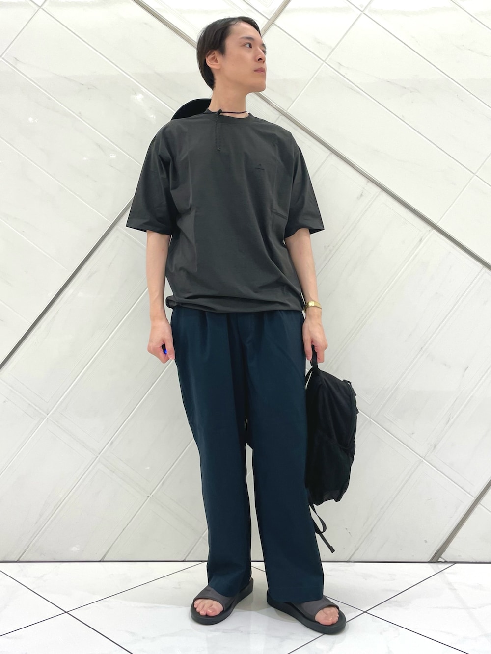 グレー系のサンダル、グレー系のTシャツ/カットソー、ブラック系のバックパック/リュックを着用したメンズの夏コーディネートの4枚目の写真