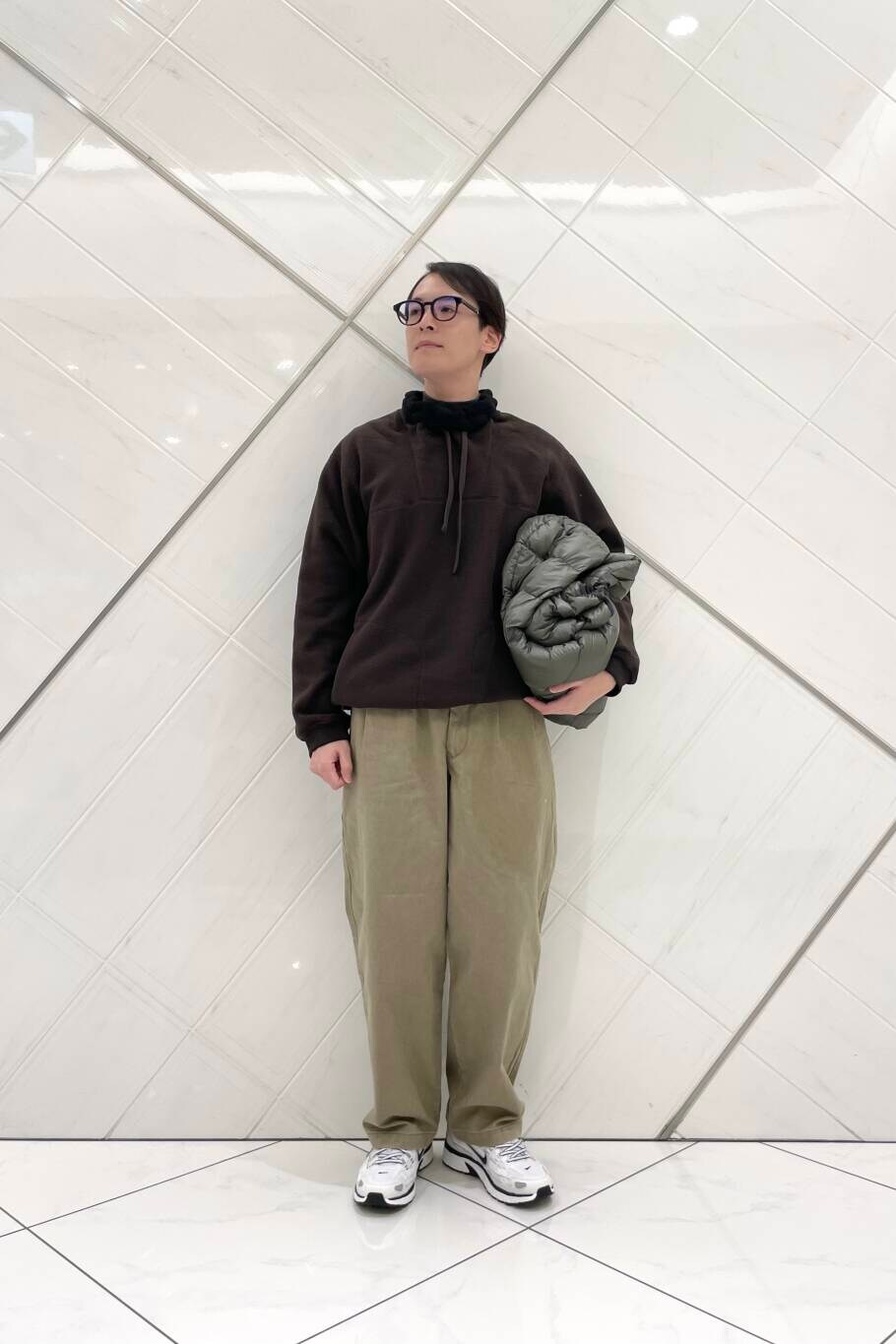 ホワイト系のスニーカー、ベージュ系のその他パンツ、グリーン系のダウンジャケット/コートを着用したメンズの冬コーディネートの6枚目の写真