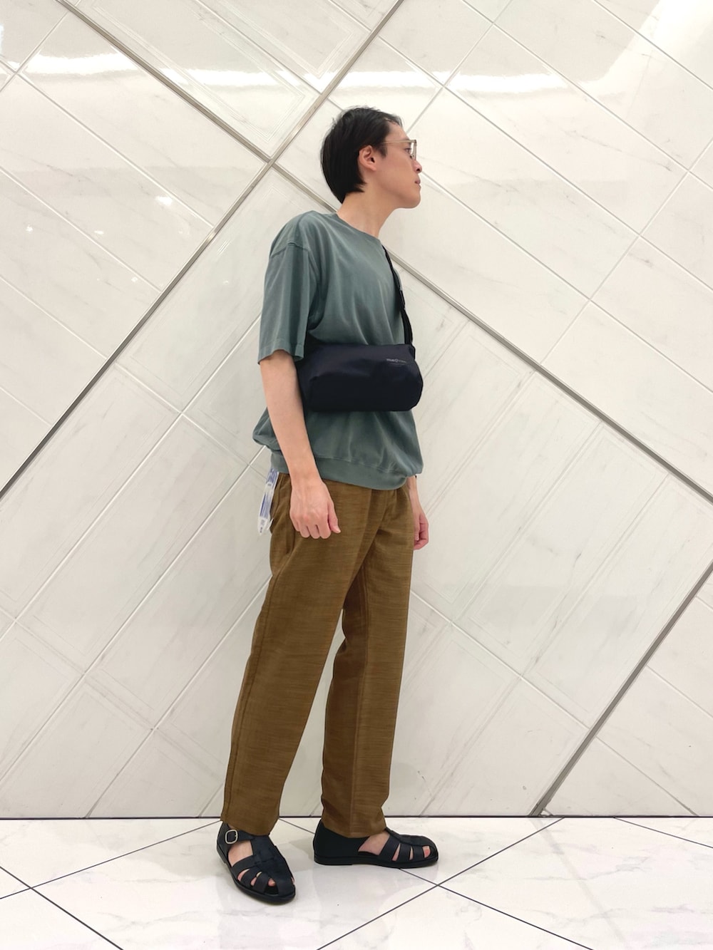 グリーン系のTシャツ/カットソー、ブラック系のショルダーバッグ、ブラウン系のその他パンツを着用したメンズの夏コーディネートの4枚目の写真