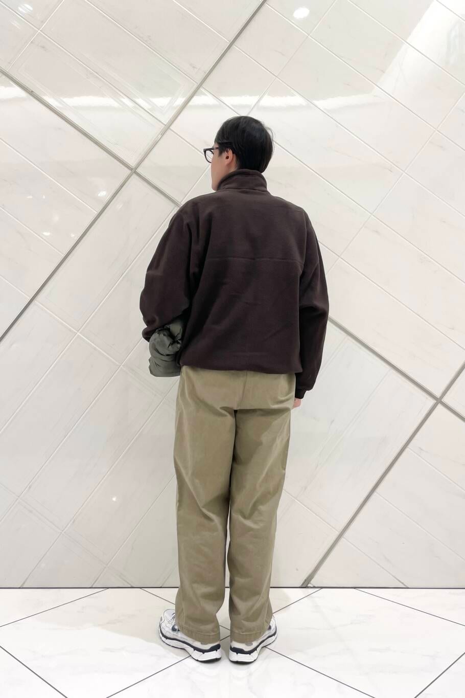 ホワイト系のスニーカー、ベージュ系のその他パンツ、グリーン系のダウンジャケット/コートを着用したメンズの冬コーディネートの7枚目の写真