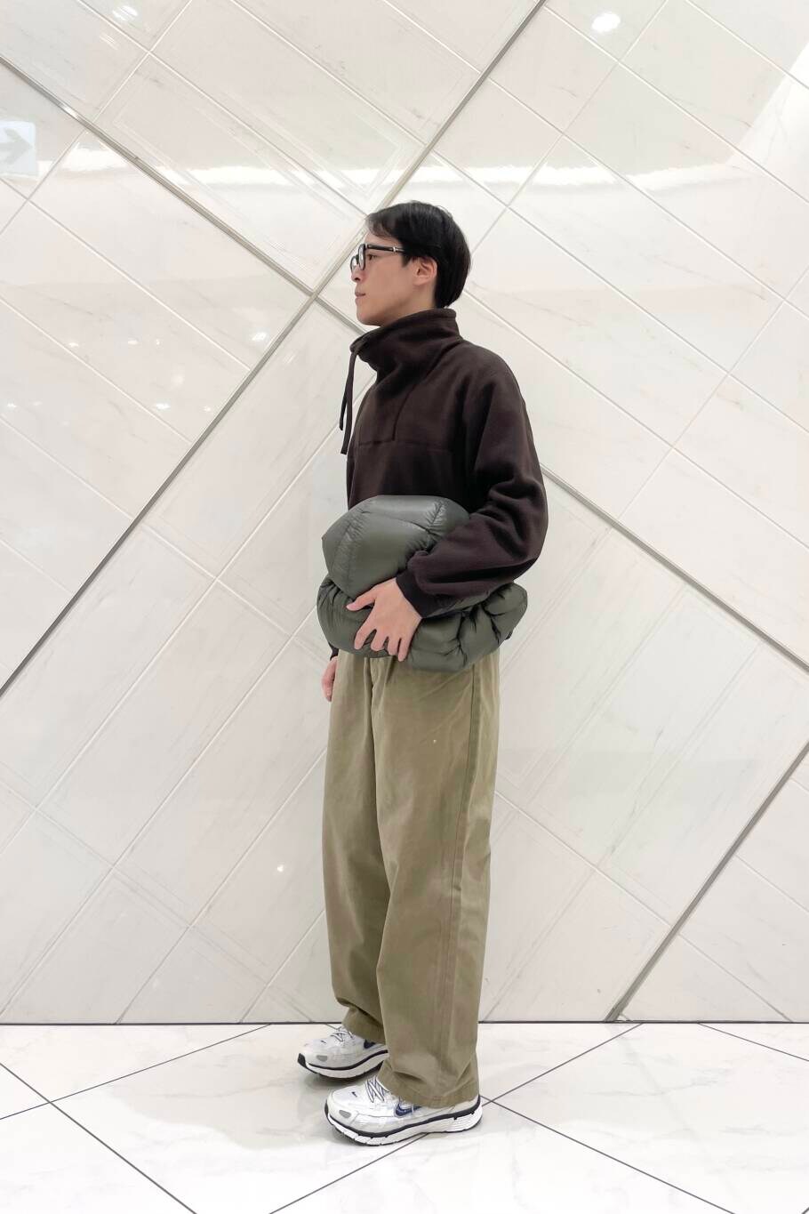 ホワイト系のスニーカー、ベージュ系のその他パンツ、グリーン系のダウンジャケット/コートを着用したメンズの冬コーディネートの8枚目の写真