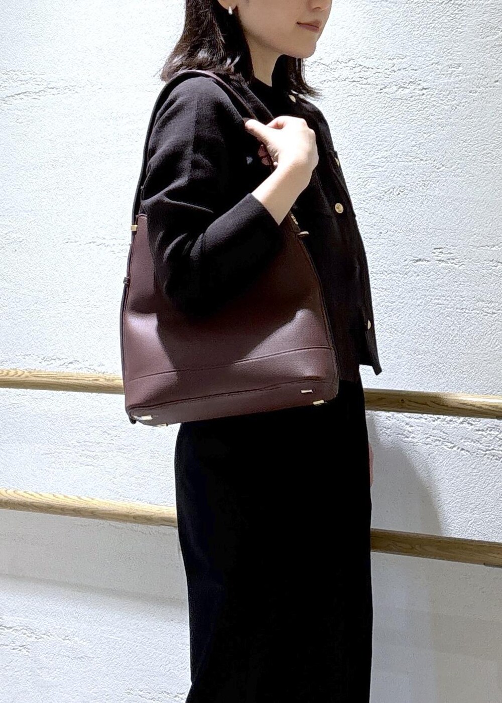 レッド系のショルダーバッグ、ブラック系のその他パンツ、ブラウン系のカーディガン/ボレロを着用したレディースの秋コーディネートの6枚目の写真