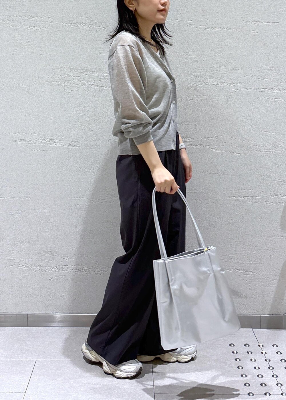 グレー系のカーディガン/ボレロ、グレー系のその他パンツ、シルバー系のトートバッグを着用したレディースの春コーディネートの3枚目の写真