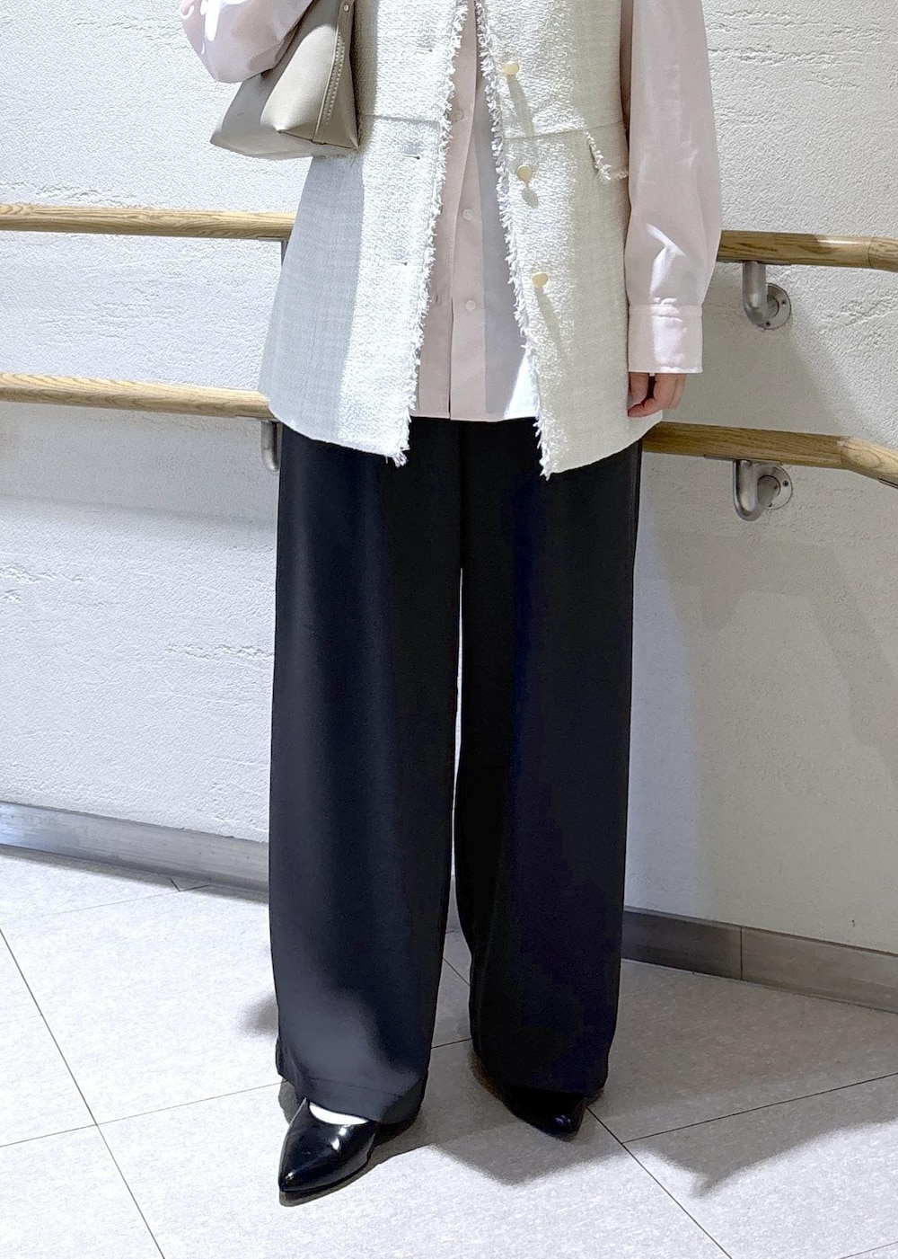 ベージュ系のショルダーバッグ、グレー系のベスト、ピンク系のシャツ/ブラウスを着用したレディースの冬コーディネートの8枚目の写真