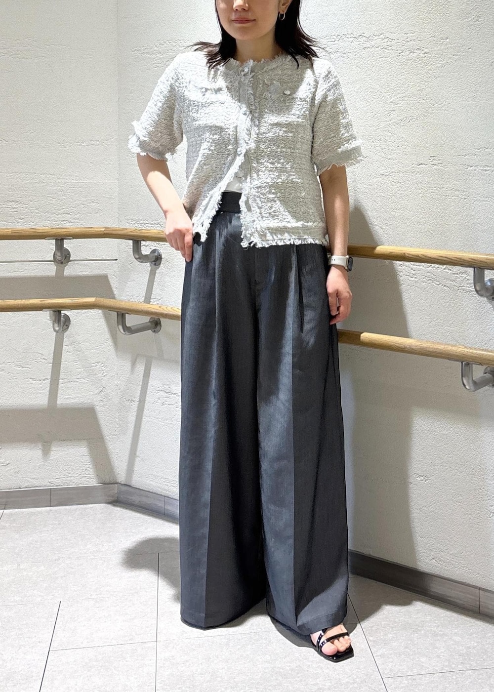 ブラック系のサンダル、ブラック系のショルダーバッグ、ホワイト系のTシャツ/カットソーを着用したレディースの夏コーディネートの2枚目の写真