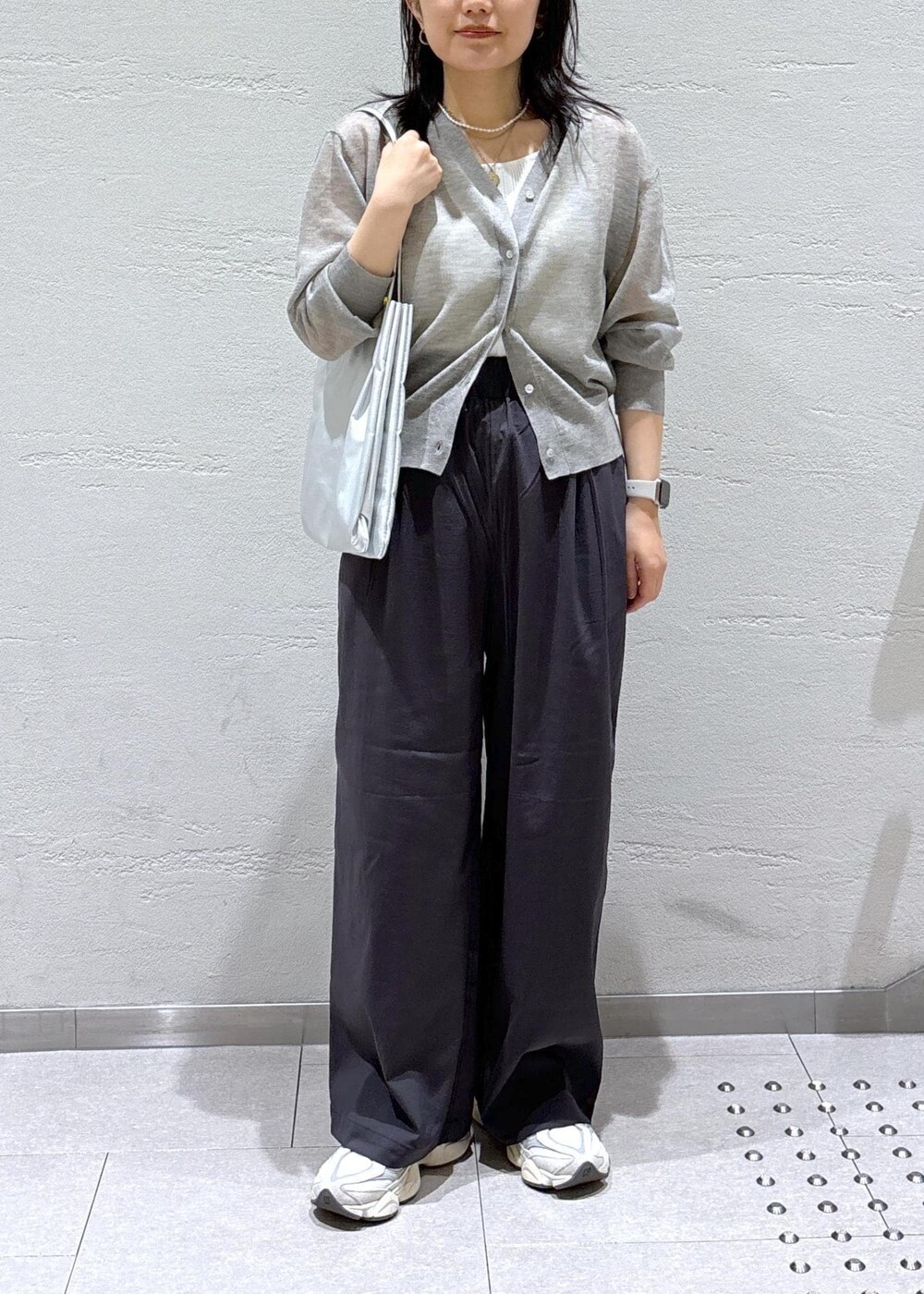 グレー系のカーディガン/ボレロ、グレー系のその他パンツ、シルバー系のトートバッグを着用したレディースの春コーディネートの2枚目の写真