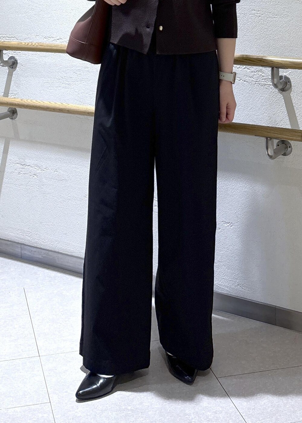 レッド系のショルダーバッグ、ブラック系のその他パンツ、ブラウン系のカーディガン/ボレロを着用したレディースの秋コーディネートの8枚目の写真