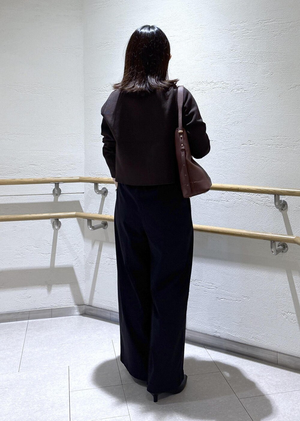 レッド系のショルダーバッグ、ブラック系のその他パンツ、ブラウン系のカーディガン/ボレロを着用したレディースの秋コーディネートの4枚目の写真