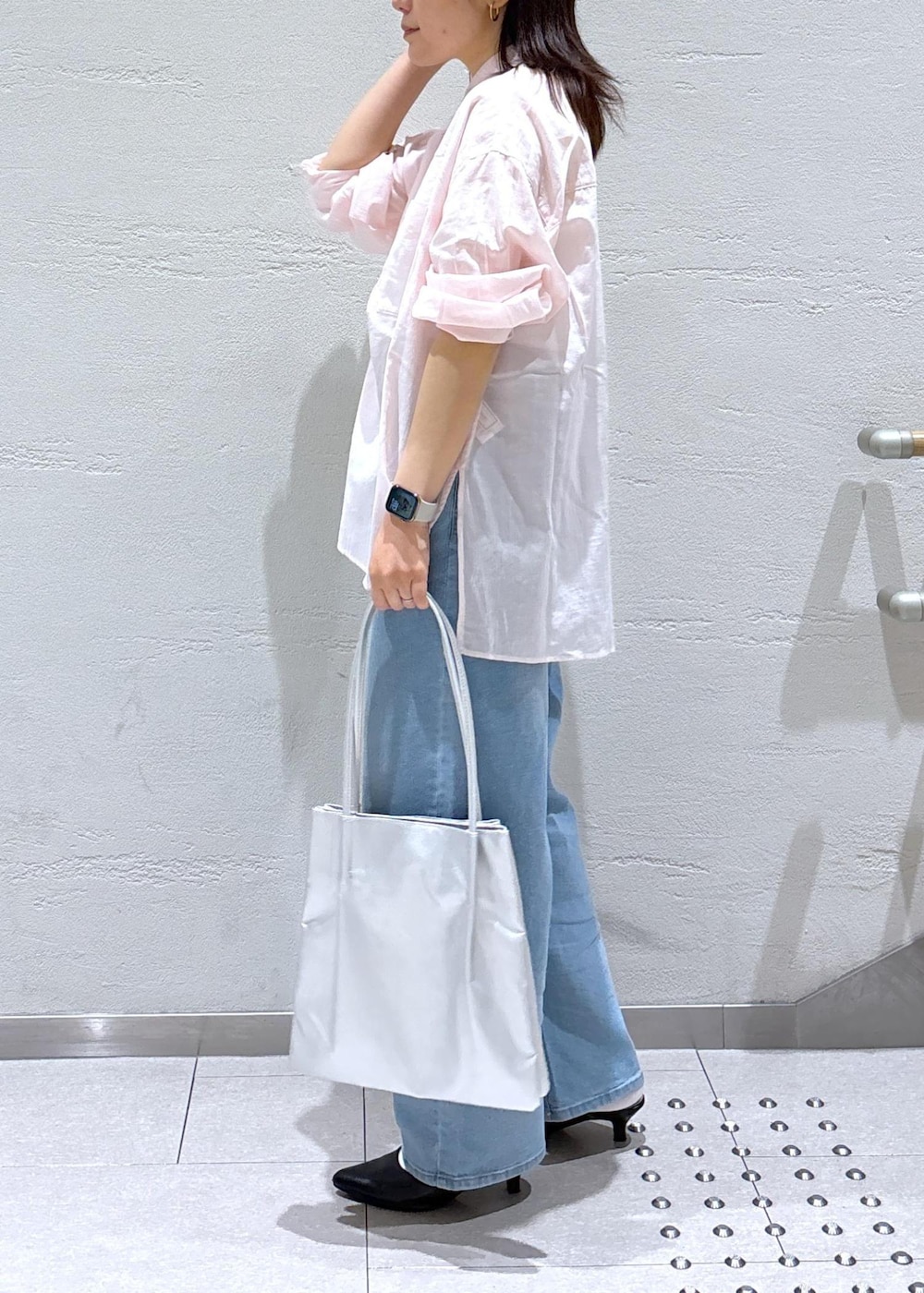 ブラック系のパンプス、ブルー系のデニムパンツ、ピンク系のシャツ/ブラウスを着用したレディースの春コーディネートの2枚目の写真