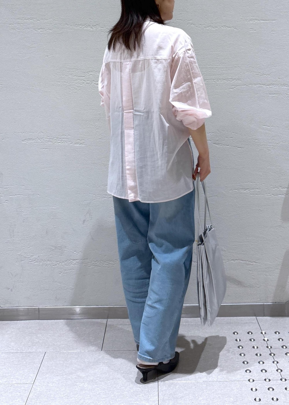 ブラック系のパンプス、ブルー系のデニムパンツ、ピンク系のシャツ/ブラウスを着用したレディースの春コーディネートの4枚目の写真