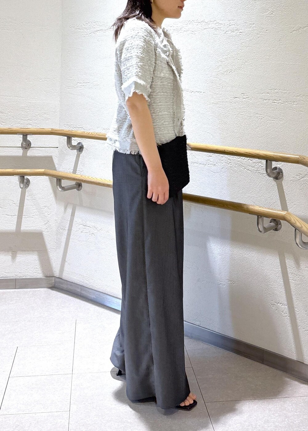 ブラック系のサンダル、ブラック系のショルダーバッグ、ホワイト系のTシャツ/カットソーを着用したレディースの夏コーディネートの3枚目の写真