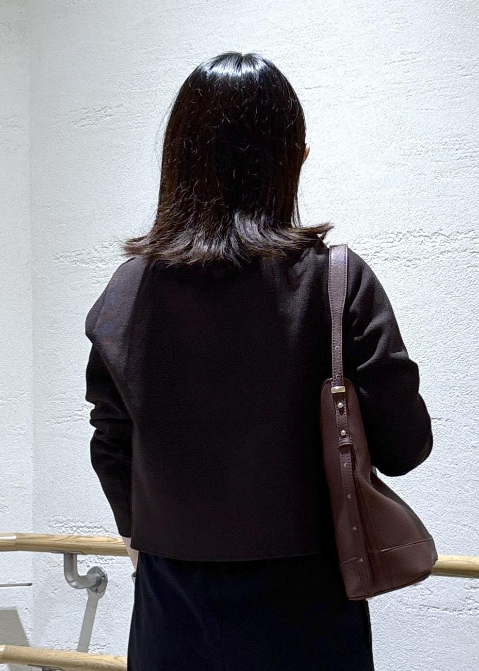 レッド系のショルダーバッグ、ブラック系のその他パンツ、ブラウン系のカーディガン/ボレロを着用したレディースの秋コーディネートの7枚目の写真