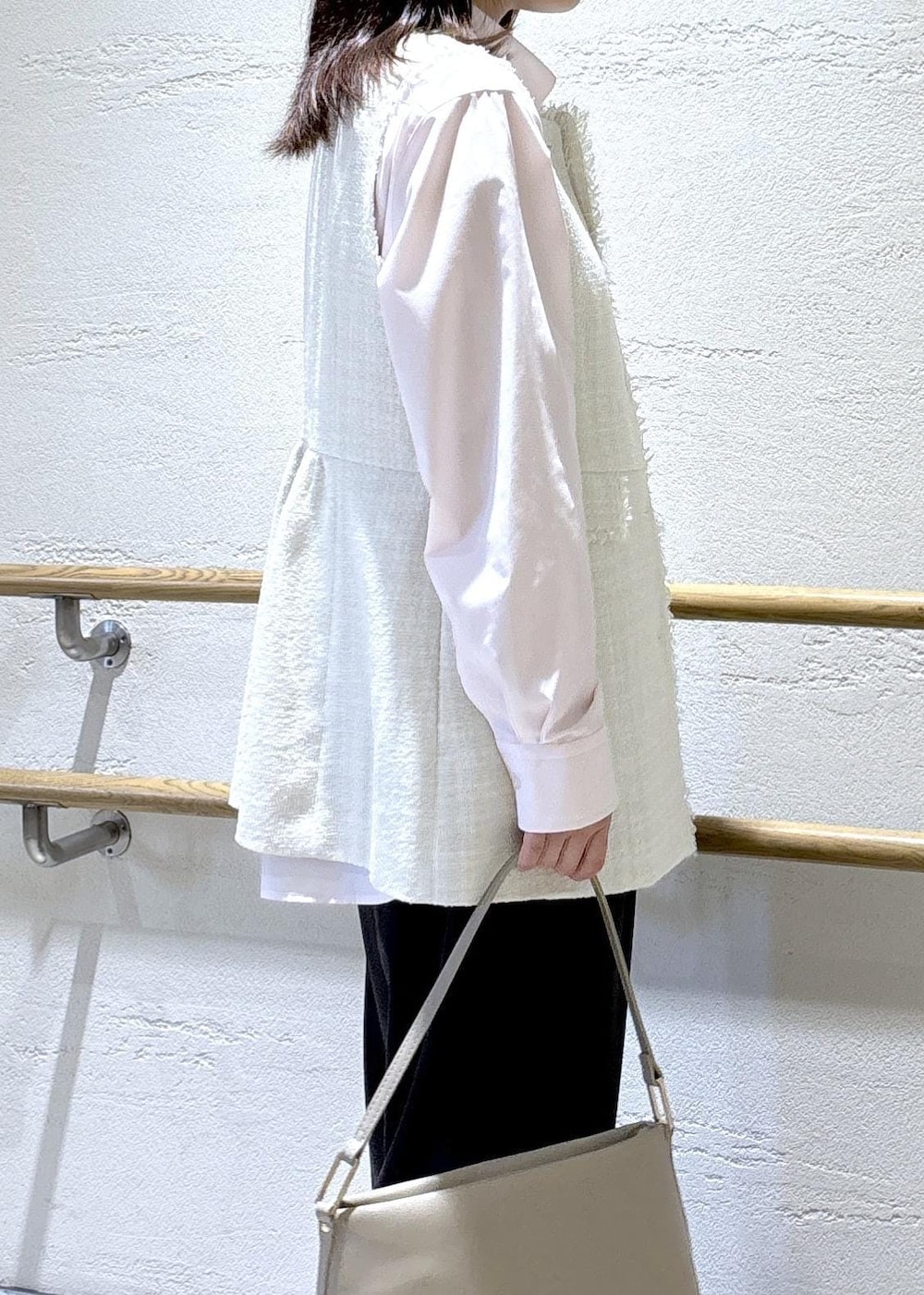 ベージュ系のショルダーバッグ、グレー系のベスト、ピンク系のシャツ/ブラウスを着用したレディースの冬コーディネートの6枚目の写真