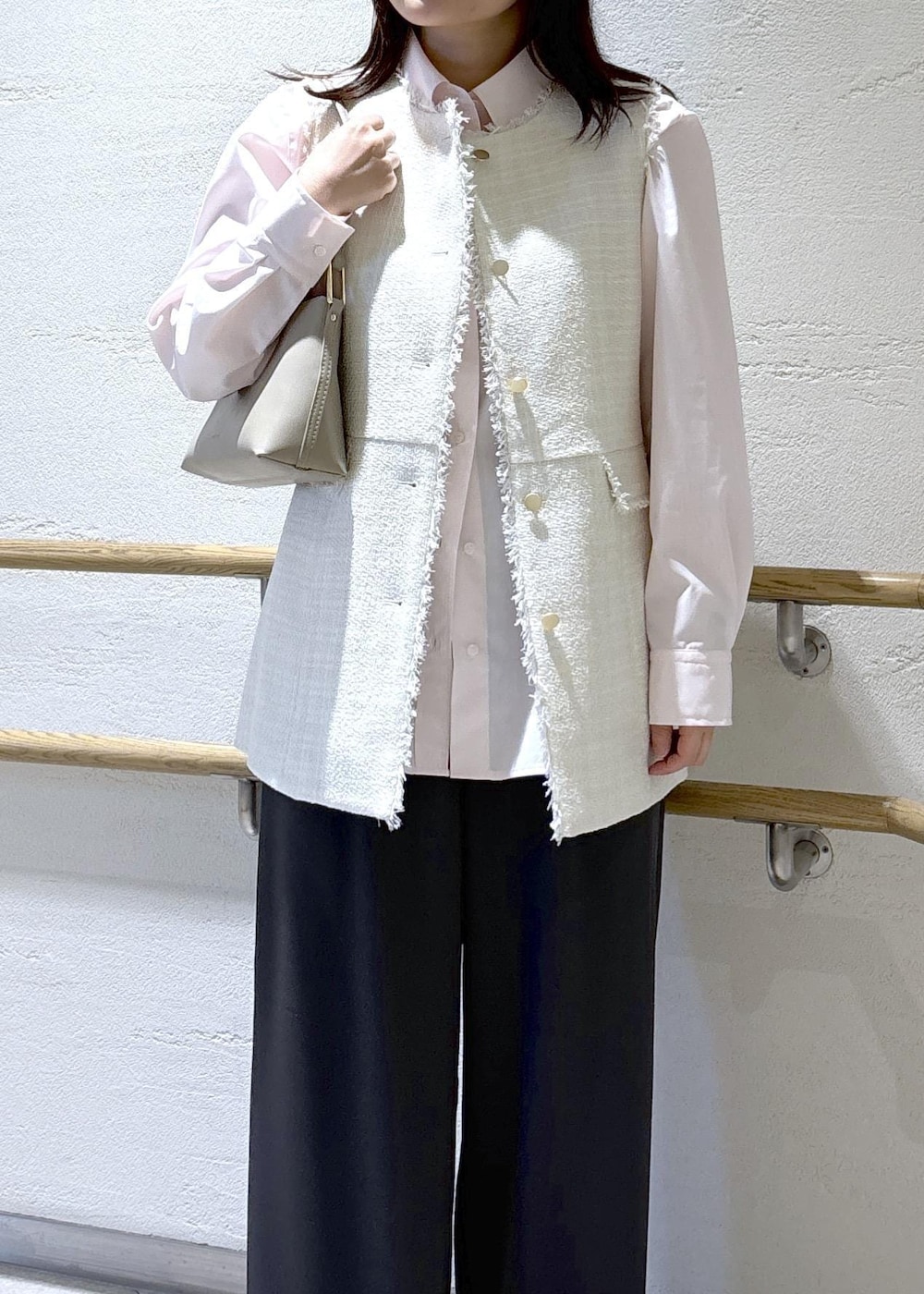 ベージュ系のショルダーバッグ、グレー系のベスト、ピンク系のシャツ/ブラウスを着用したレディースの冬コーディネートの5枚目の写真