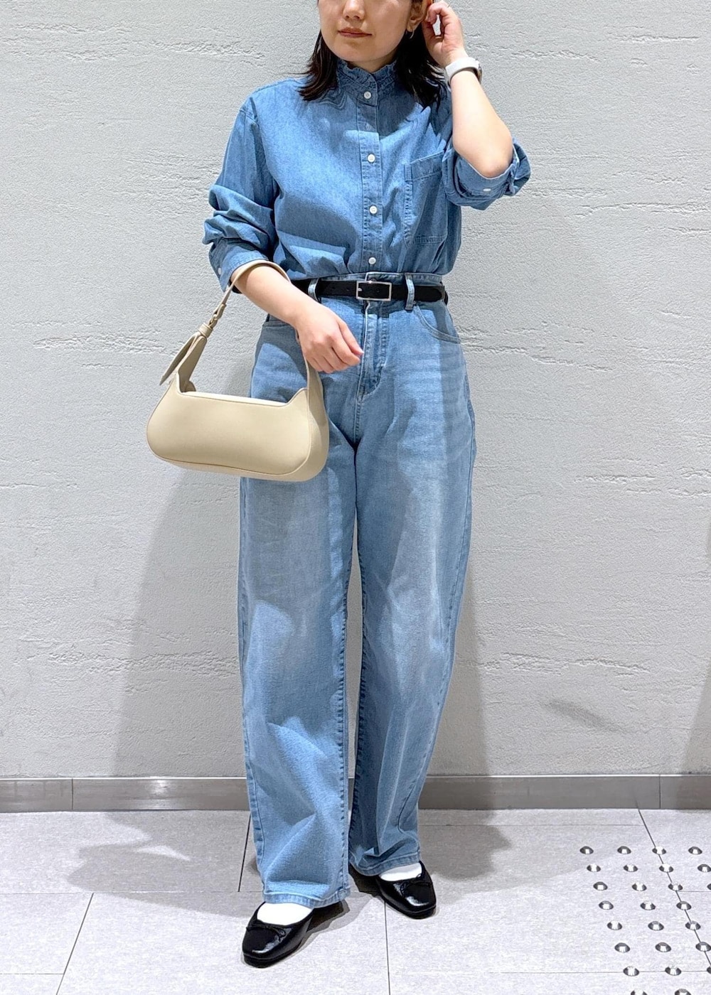 ブルー系のデニムパンツ、ベージュ系のハンドバッグ、ホワイト系のノーカラージャケットを着用したレディースの冬コーディネートの7枚目の写真