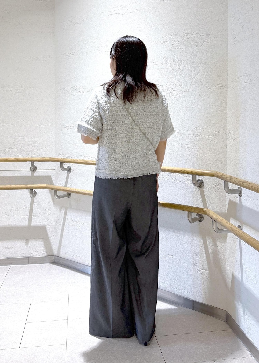 ブラック系のサンダル、ブラック系のショルダーバッグ、ホワイト系のTシャツ/カットソーを着用したレディースの夏コーディネートの4枚目の写真