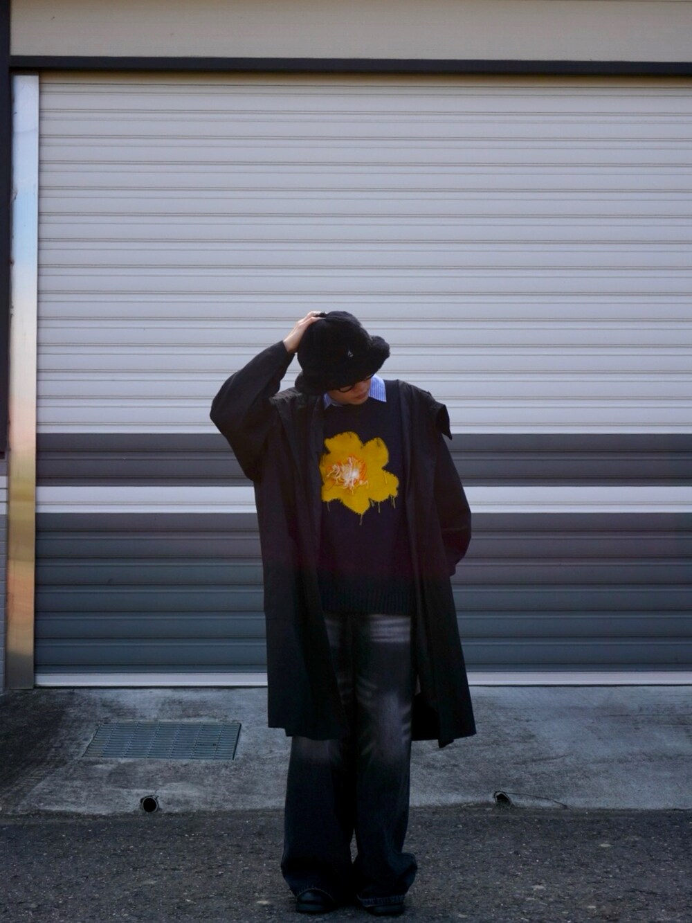 ブルー系のニット/セーター、ブラック系のハットを着用したメンズの冬コーディネートの2枚目の写真