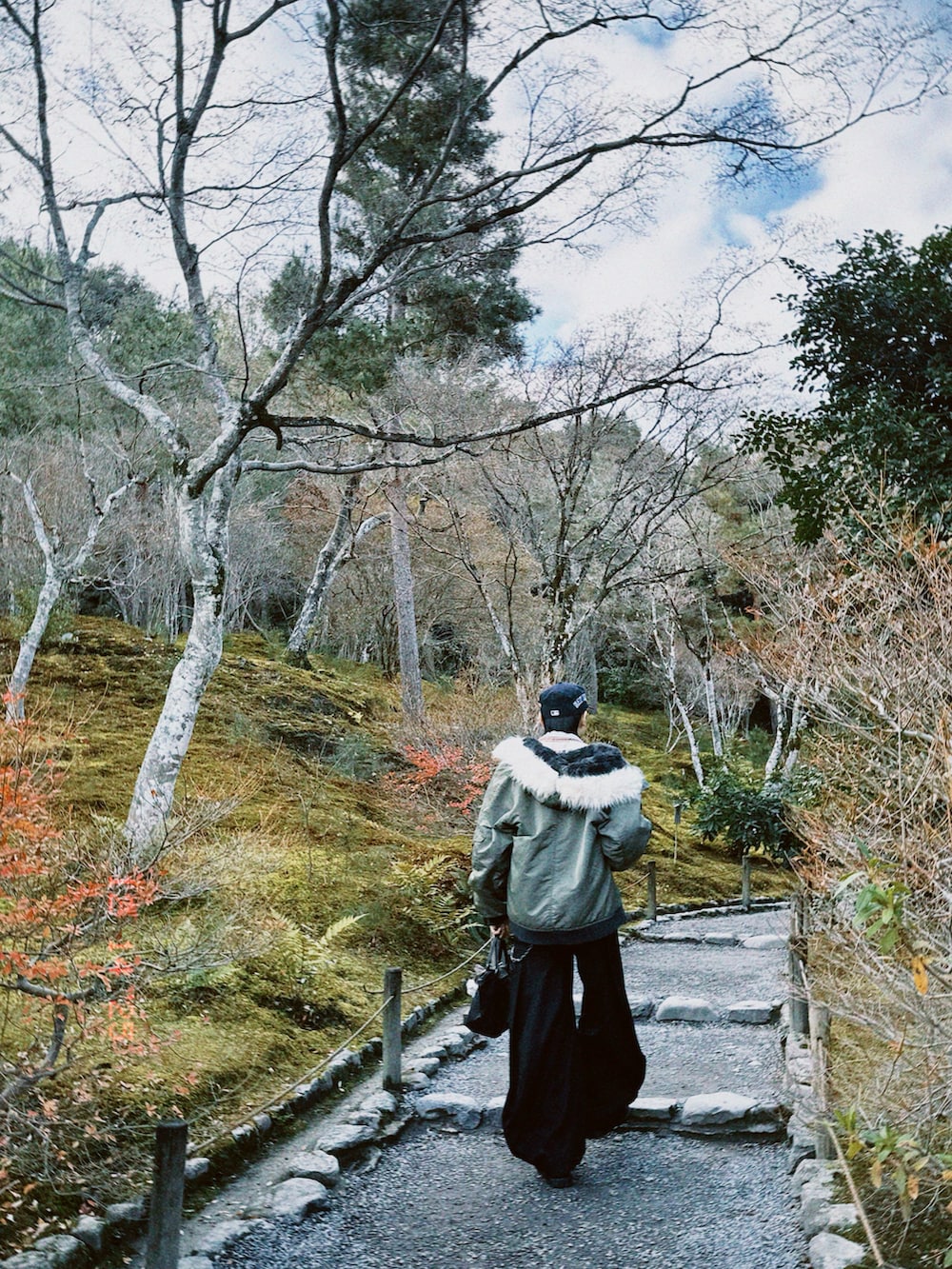 グリーン系のMA-1、ブラック系のトートバッグ、ブラック系のパンツを着用したメンズの冬コーディネートの5枚目の写真