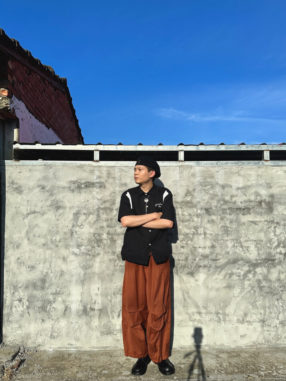 ブラック系のシャツ/ブラウス、オレンジ系のパンツ、ブラック系のキャップを着用したメンズの春コーディネートの3枚目の写真