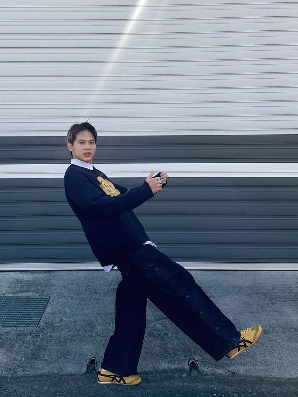 ブルー系のデニムパンツ、イエロー系のスニーカー、ブルー系のニット/セーターを着用したメンズの冬コーディネートの4枚目の写真