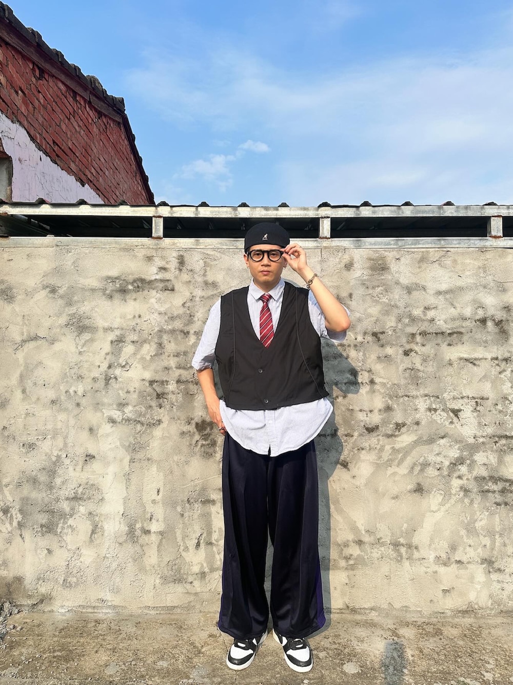 ブラック系のスーツベスト、ブルー系のその他パンツ、ブラック系のスニーカーを着用したメンズの春コーディネートの2枚目の写真