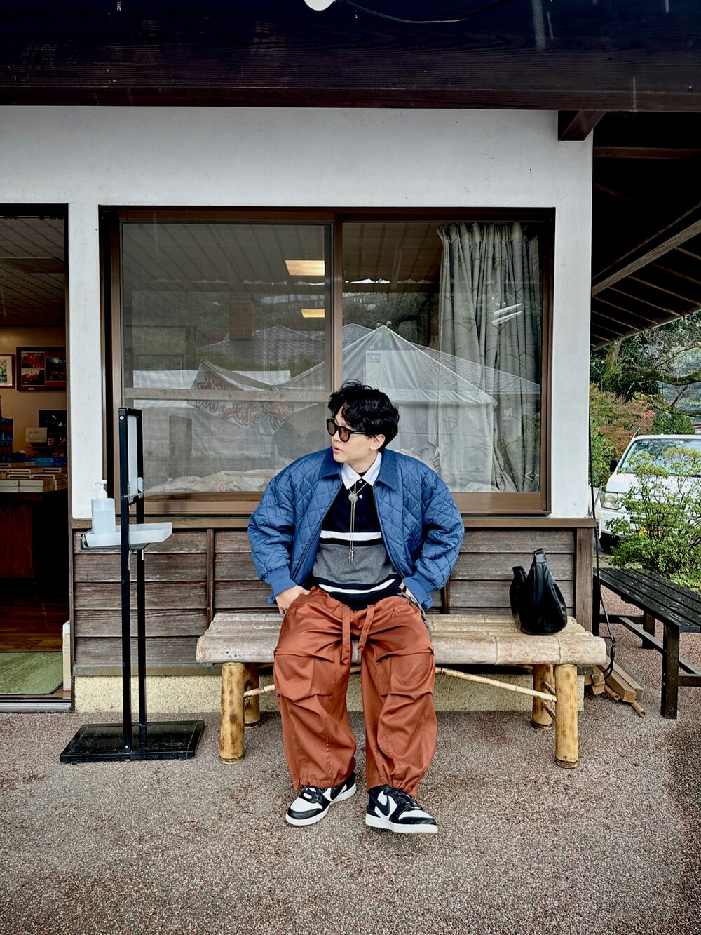 ブラック系のポロシャツ、ブルー系のジャケット/アウター、オレンジ系のパンツを着用したメンズの冬コーディネートの2枚目の写真