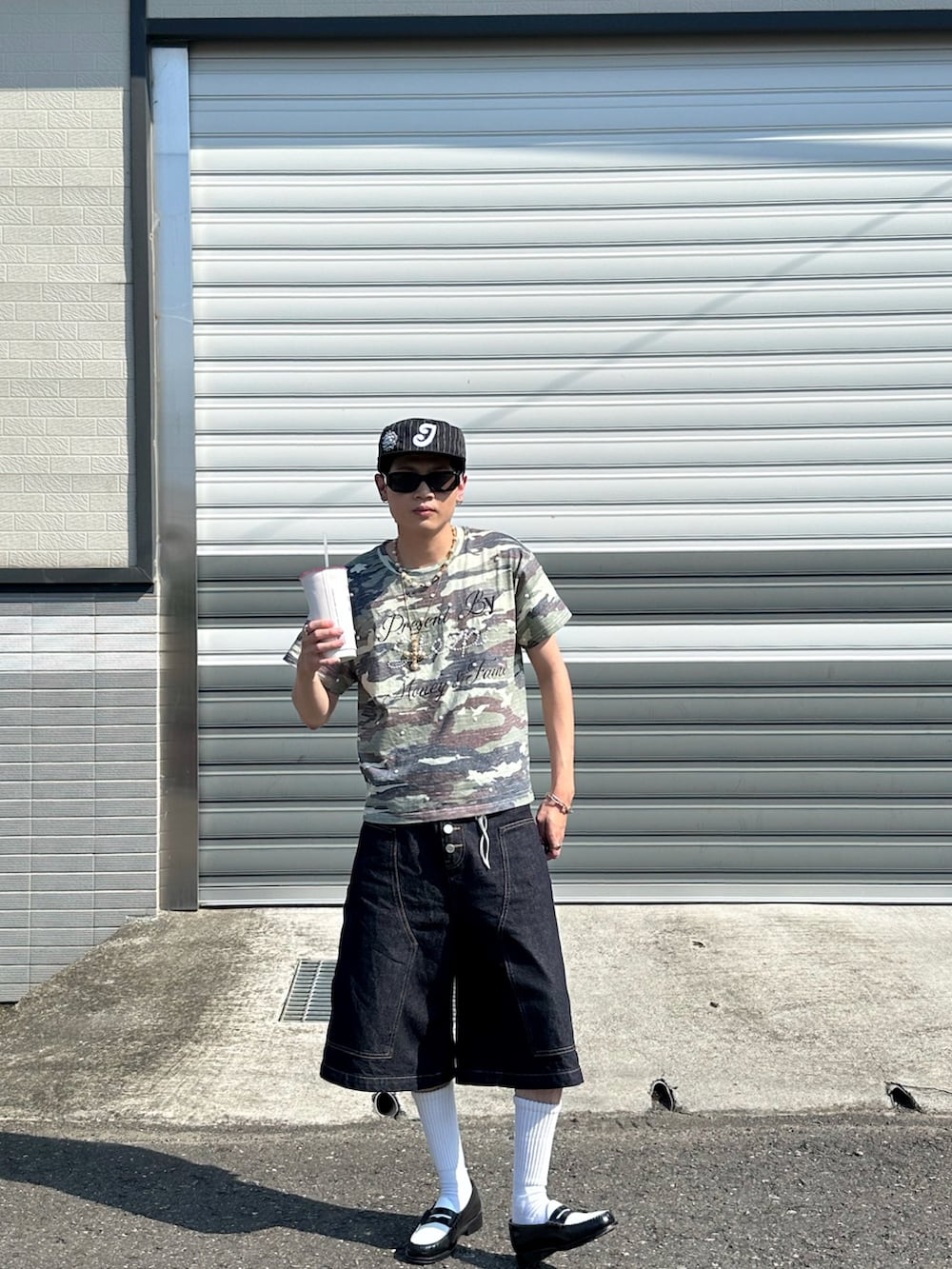 グリーン系のTシャツ/カットソー、ブラック系のデニムパンツ、ブラック系のローファーを着用したメンズの夏コーディネートの3枚目の写真