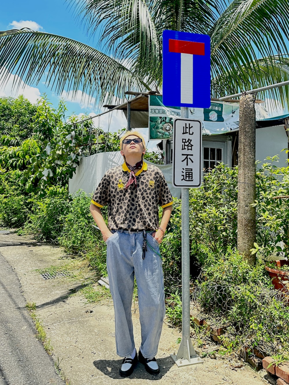 イエロー系のポロシャツ、ブルー系のデニムパンツ、ブラック系のローファーを着用したメンズの夏コーディネートの3枚目の写真