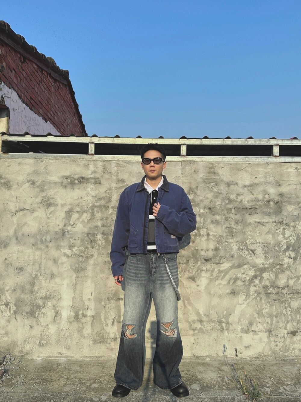 ブルー系のデニムパンツ、ブラック系のポロシャツ、ブルー系のジャケット/アウターを着用したメンズの春コーディネートの3枚目の写真