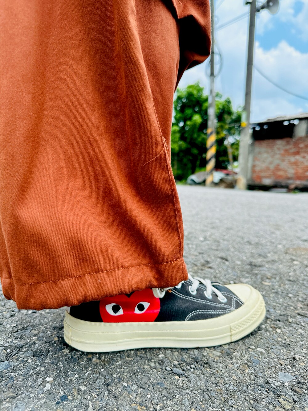 オレンジ系のパンツ、ブラック系のスニーカー、オレンジ系のサングラスを着用したメンズの夏コーディネートの5枚目の写真